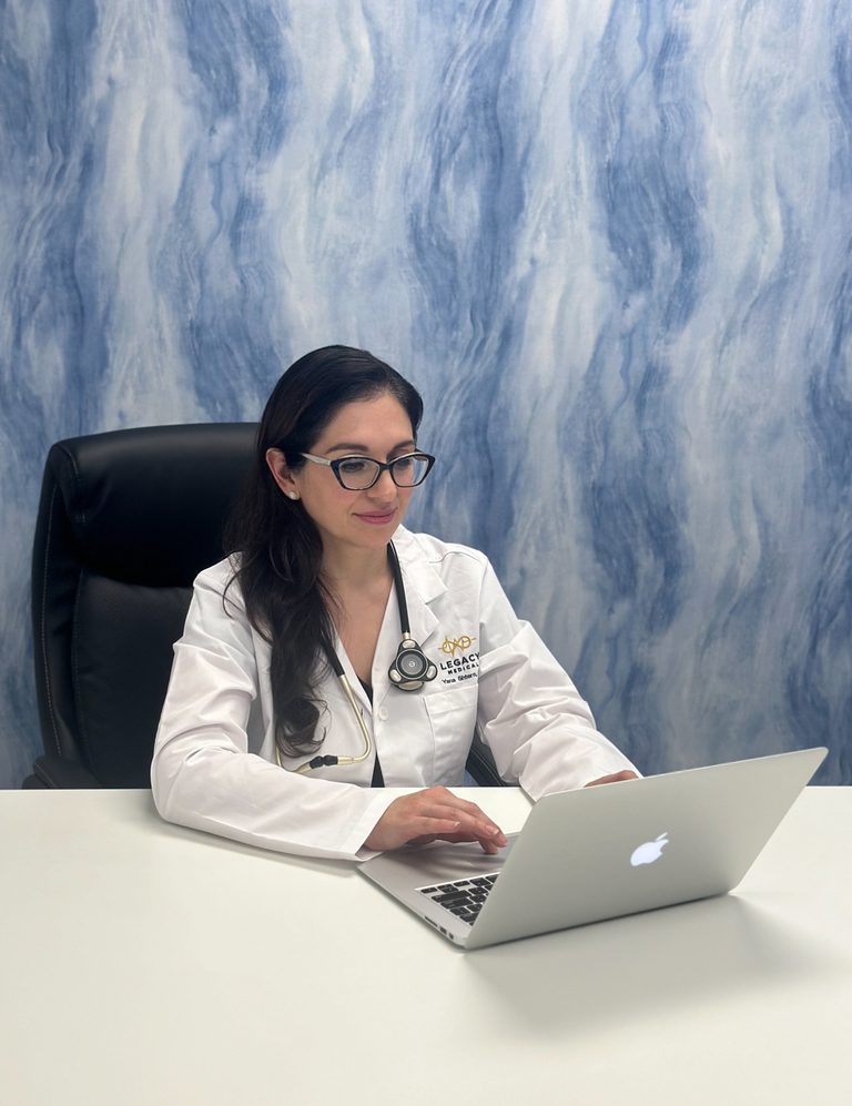 Dr. Yana Shtern at her desk with a laptop