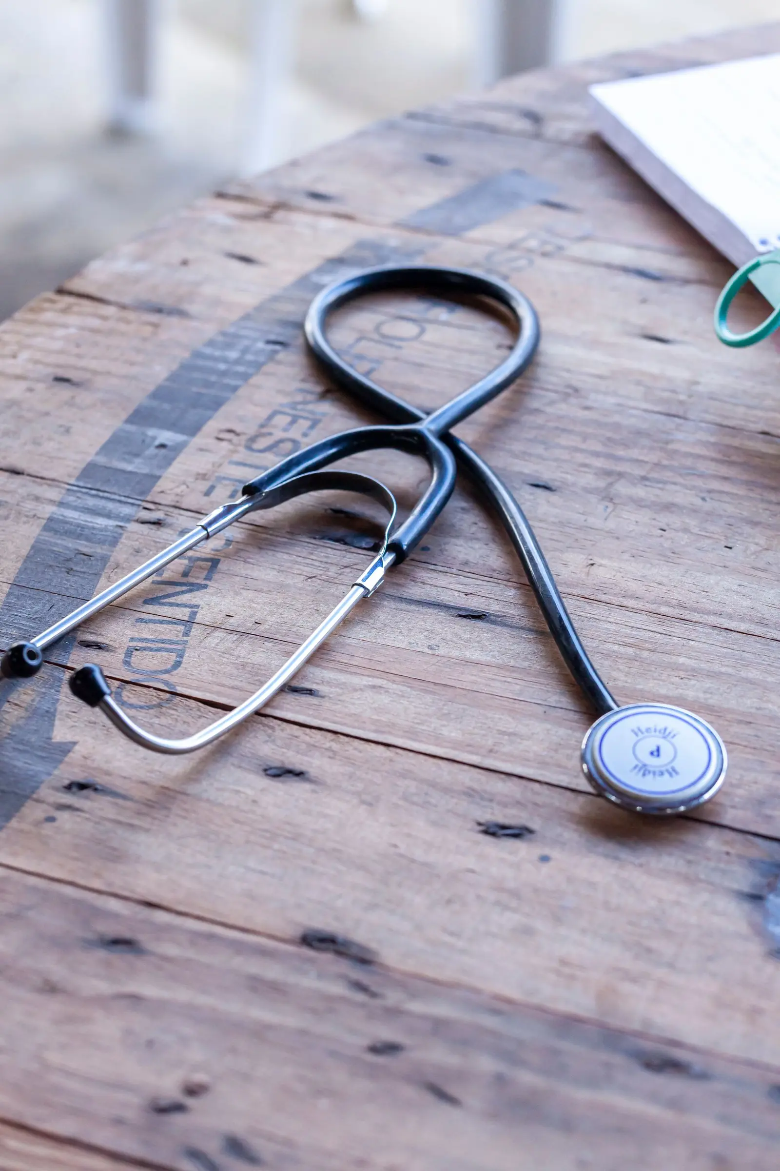 A stethoscope resting on a weathered wooden table.