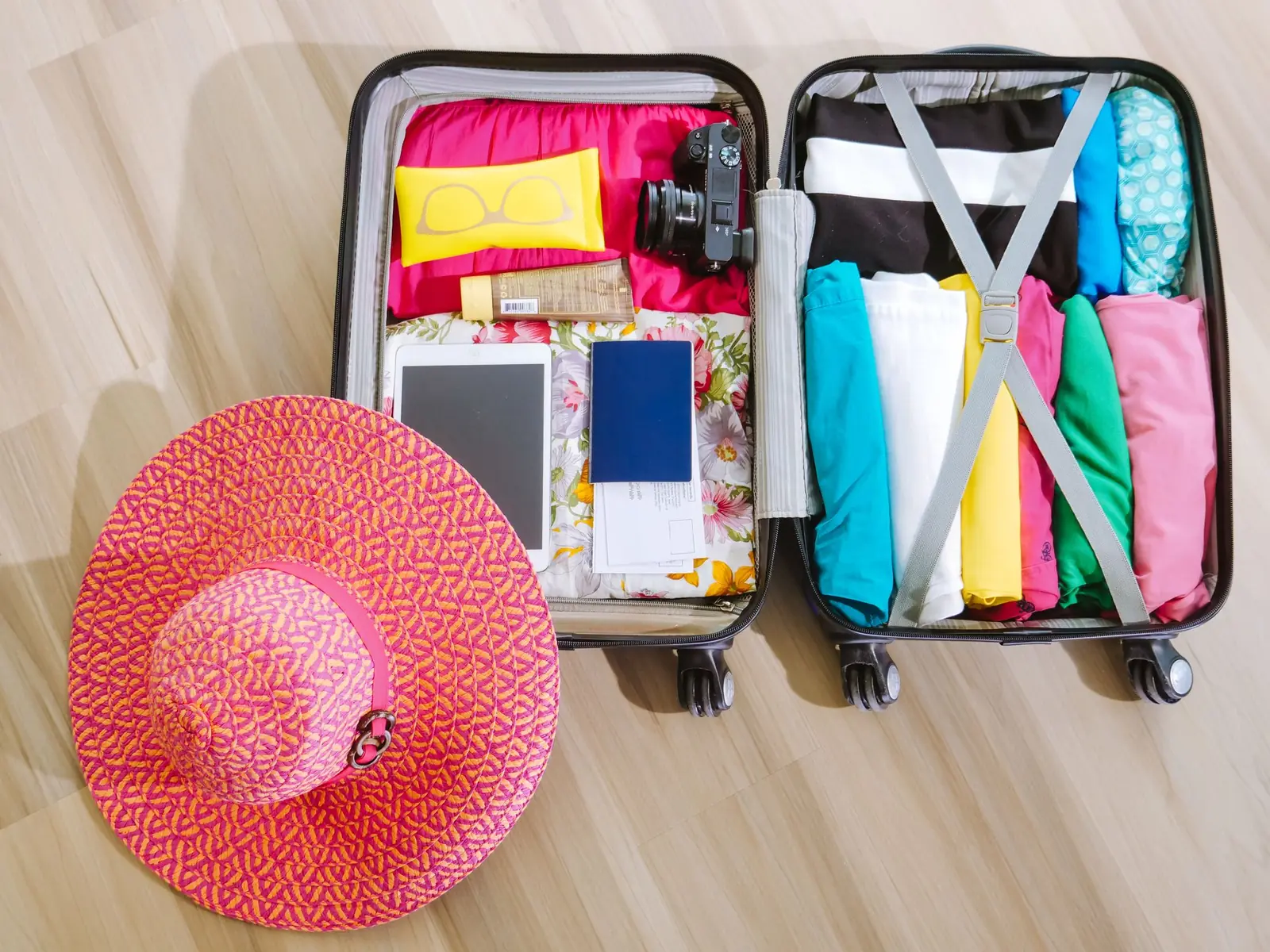 A packed suitcase with a sun hat, ready for travel.