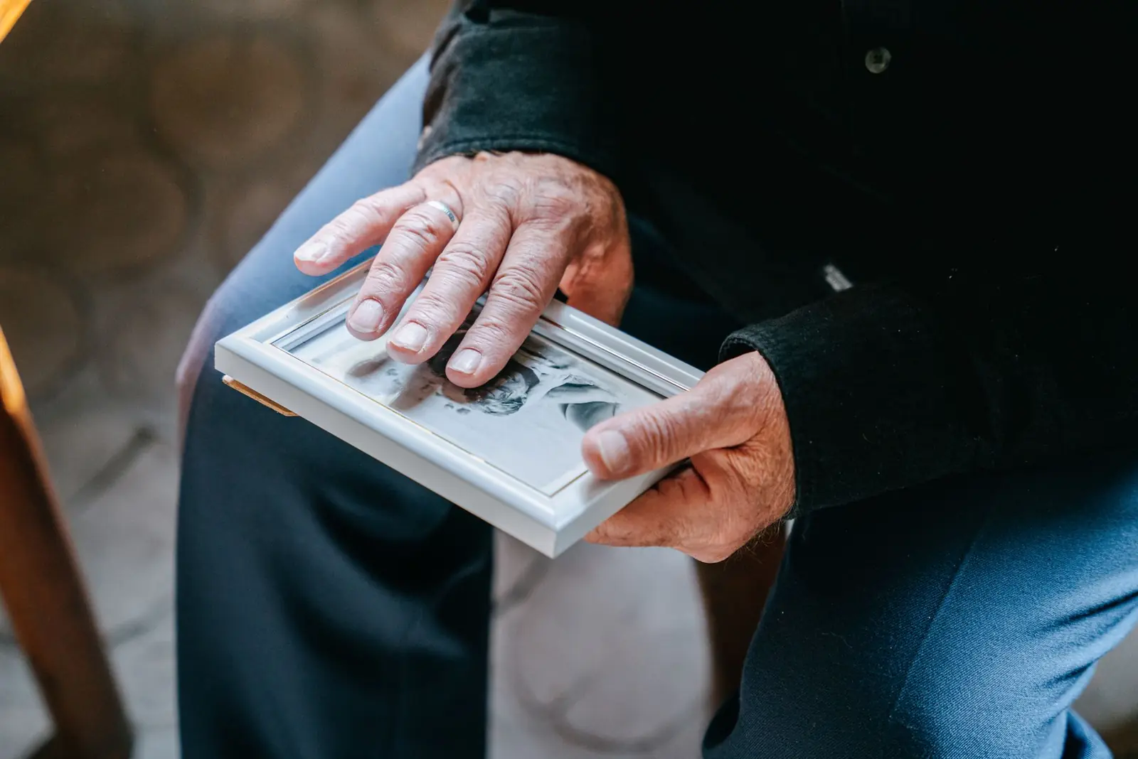 Older hands holding a framed family photograph.